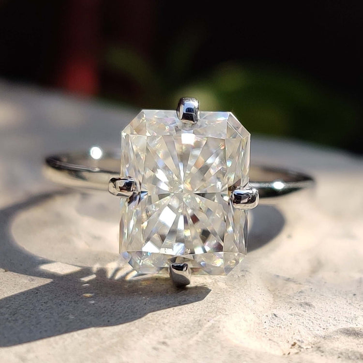 White gold solitaire engagement ring with radiant cut moissanite.
