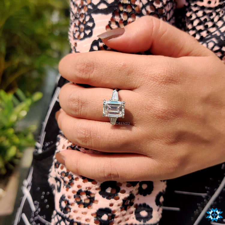 Emerald cut center stone with bullet cut side stones in white gold.
