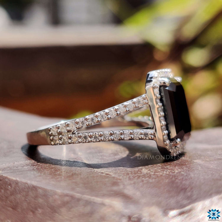 White gold ring featuring black emerald moissanite and round halo surround.
