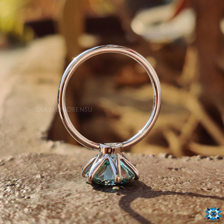 White gold solitaire ring featuring a round moissanite center stone.
