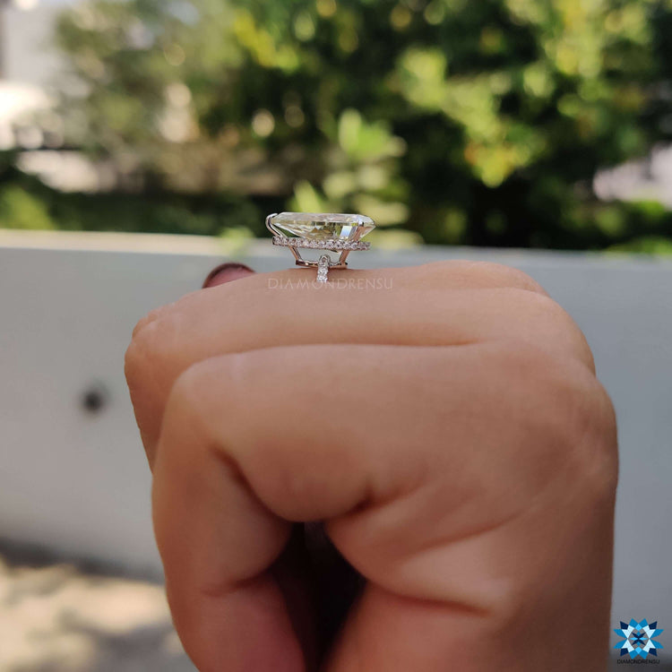 Hidden halo engagement ring with pear cut moissanite center.
