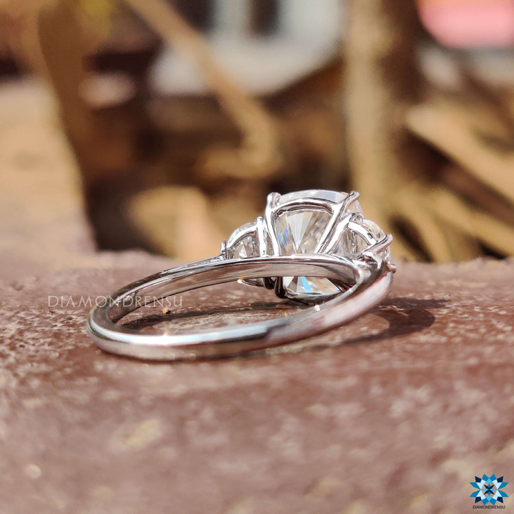 Cushion cut moissanite set in prong with half moon accents.
