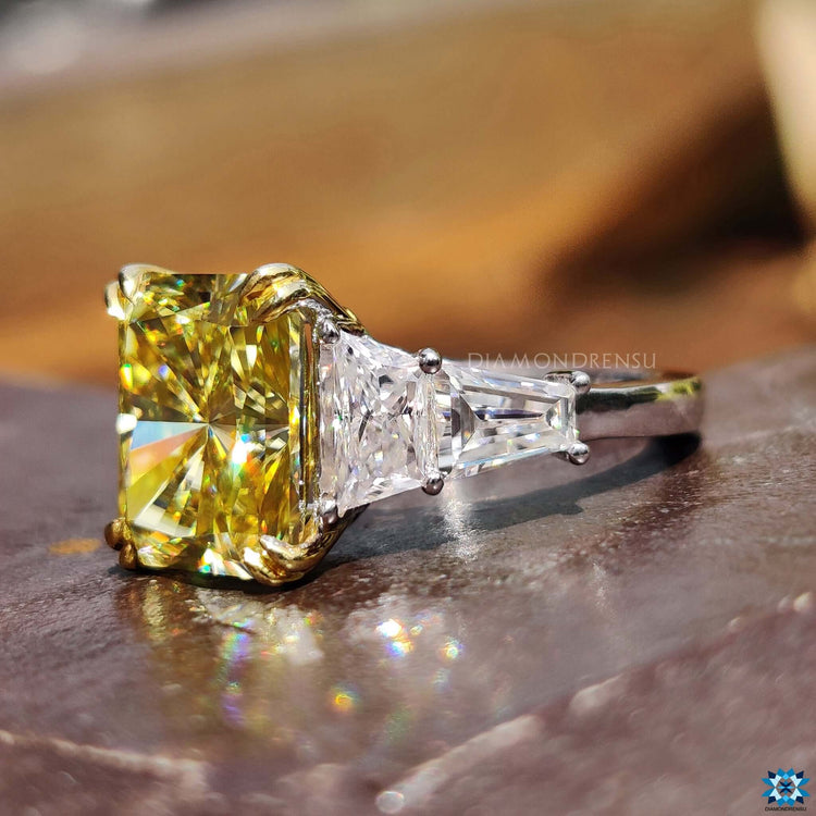 Moissanite engagement ring with radiant cut centerpiece.

