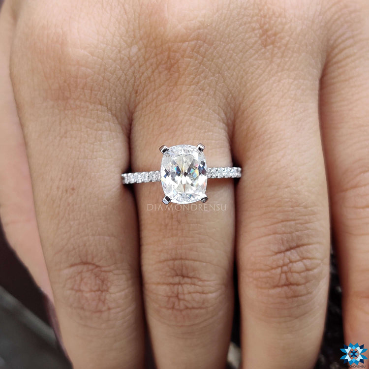 Cathedral setting ring with moissanite cushion cut centerpiece.

