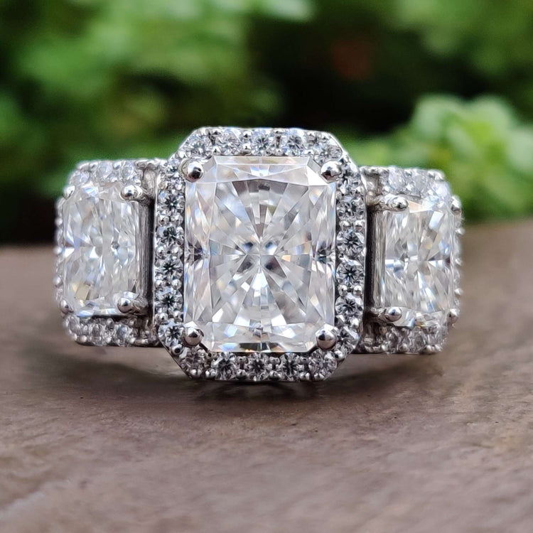 Radiant cut moissanite engagement ring with three stone setting.
