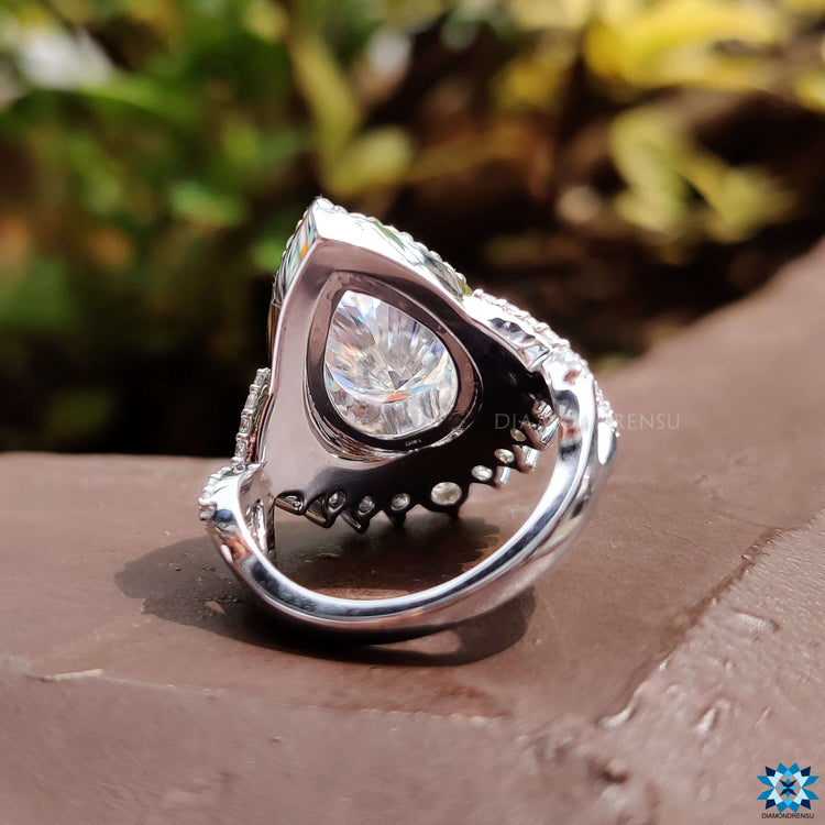 Handmade moissanite ring with pear shaped center stone.
