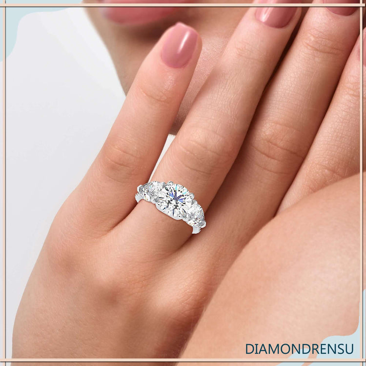 Designer ring featuring round cut diamond with pear side stones.
