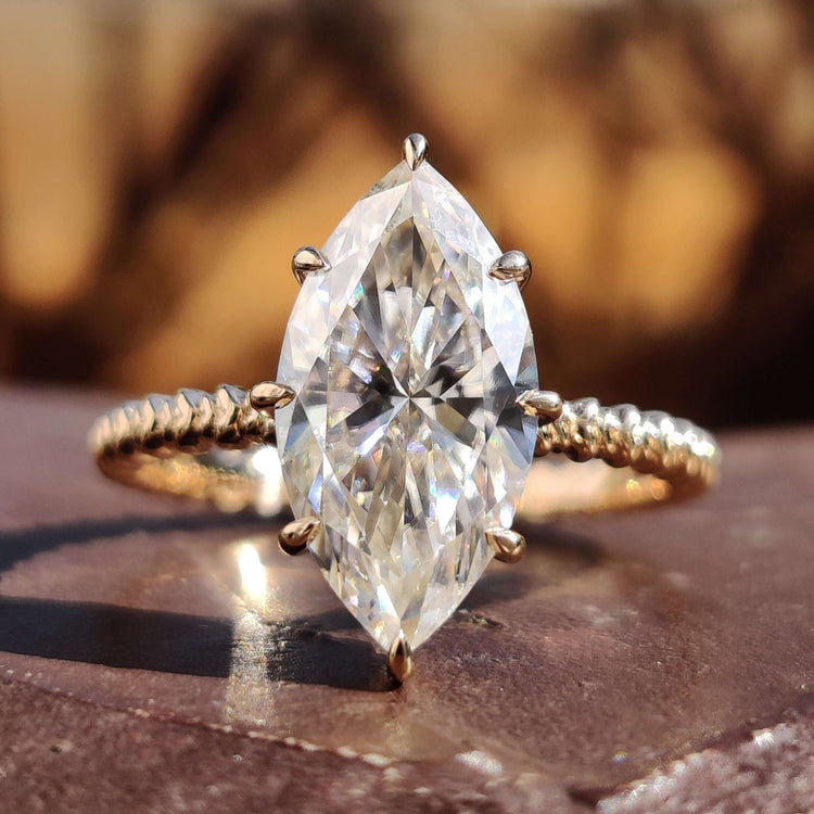 Marquise solitaire ring with yellow gold band.
