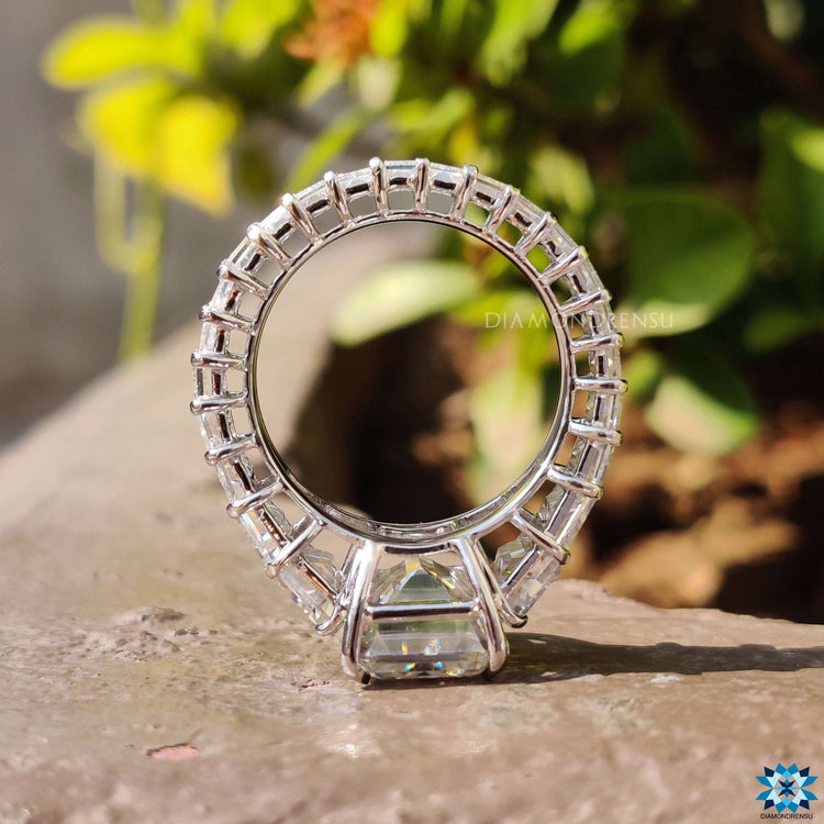 Custom pave ring with emerald cut center in white gold.
