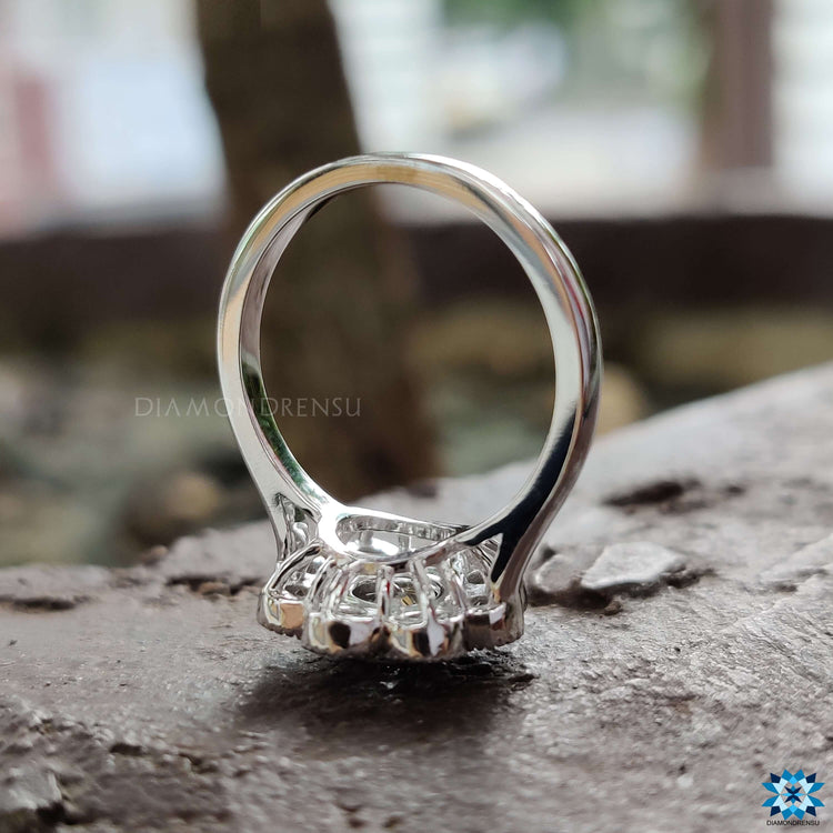 Bezel set round moissanite ring with brilliant cut stones and halo finish.
