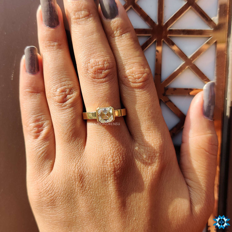 Yellow gold ring with Asscher cut center stone.
