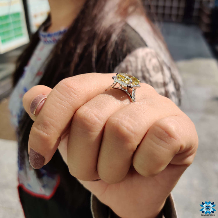 Four prong yellow moissanite engagement ring with halo.
