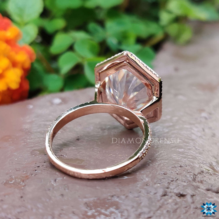 Custom moissanite ring featuring bezel and pave setting.
