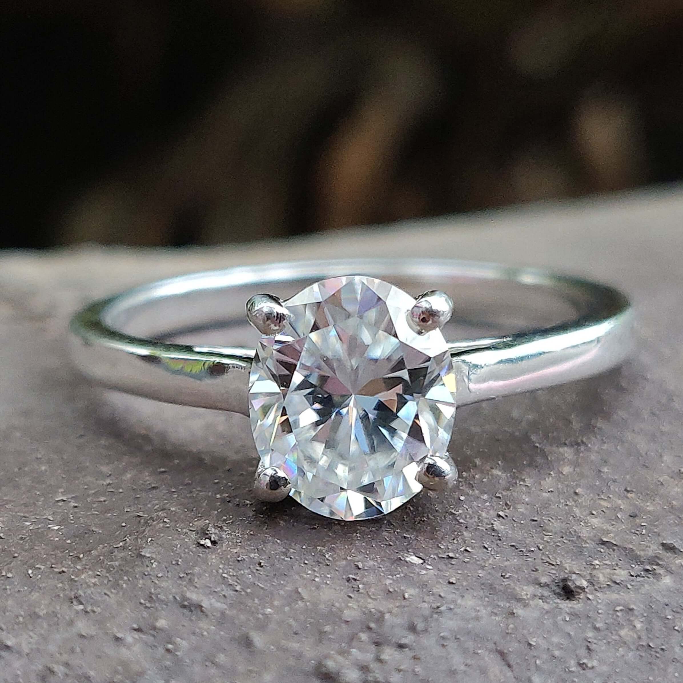 Oval moissanite engagement ring with a 4 round prong set in a white gold cathedral setting.
