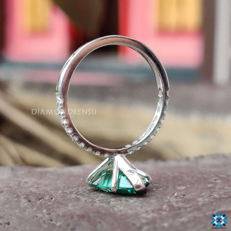 Custom engagement ring with green pear cut moissanite.
