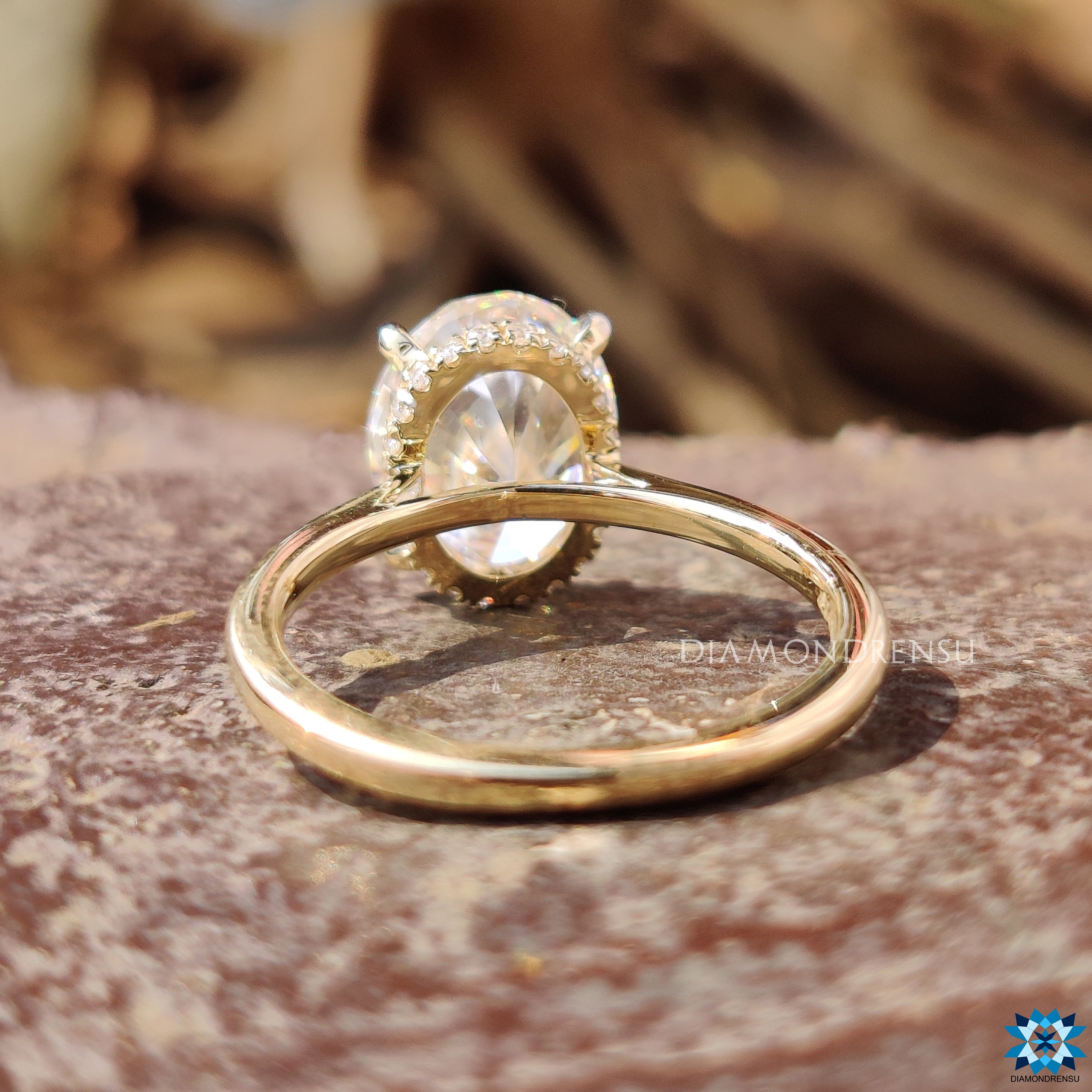 Oval moissanite ring with 4 claw setting and round halo effect.
