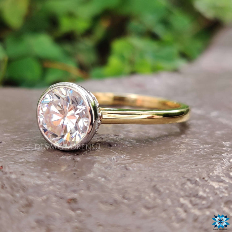 Handmade round bezel moissanite ring in gold.
