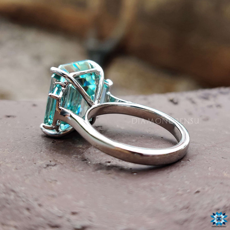 Emerald cut center stone with geometric side stones.
