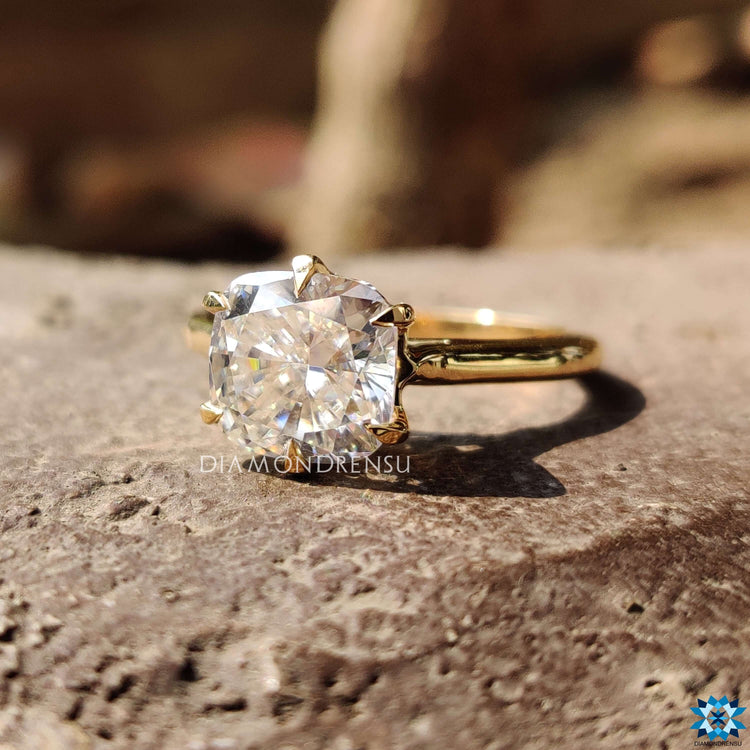 Six prong yellow gold ring with cushion cut moissanite.
