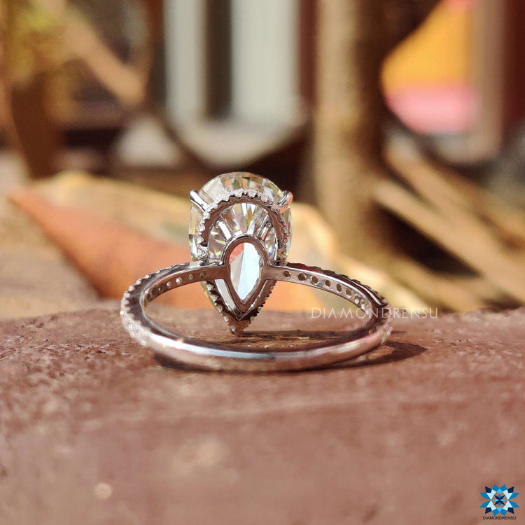 Custom engagement ring with pear cut moissanite and pave set round stones.

