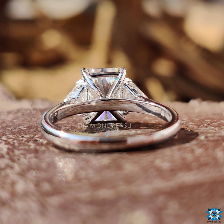 White gold cathedral setting ring with radiant and side stones.
