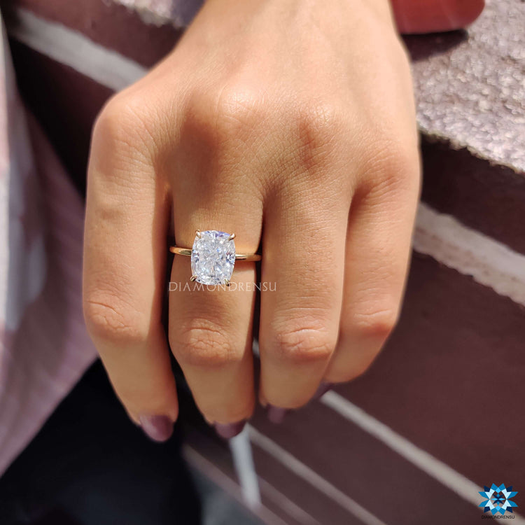 Solitaire setting ring featuring an elongated cushion cut moissanite.
