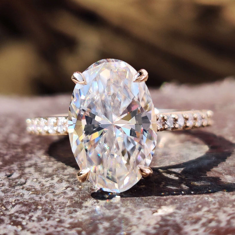 Oval moissanite ring with hidden halo design.
