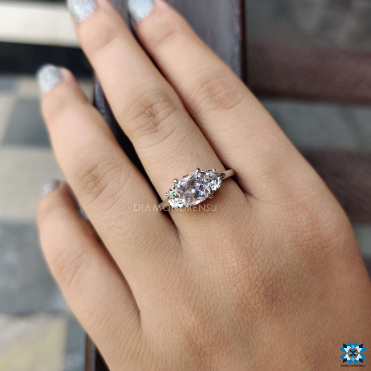 Elegant white gold ring with moissanite cushion and half moons.
