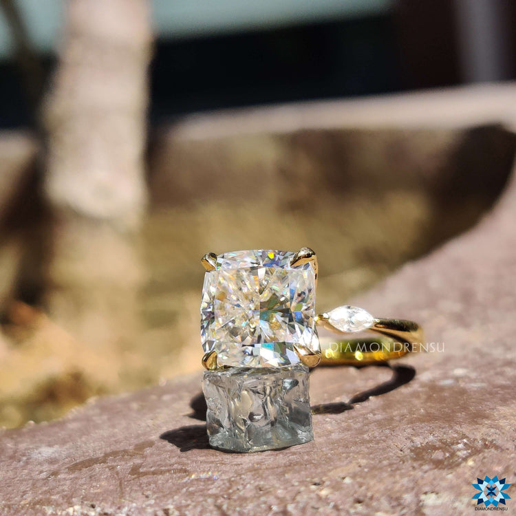 Custom engagement ring with cushion and pear moissanite stones in a classic setting.
