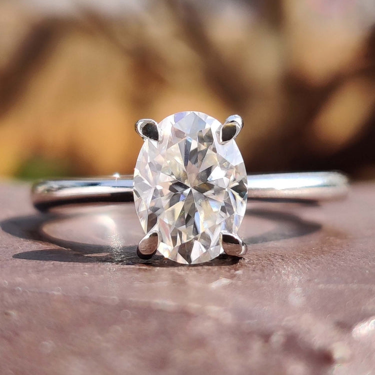 Oval cut moissanite solitaire ring in white gold with a 4 claw prong setting.
