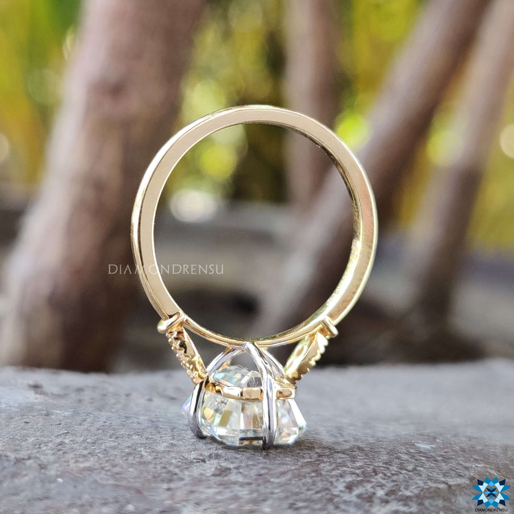Yellow gold ring with emerald cut moissanite center stone.
