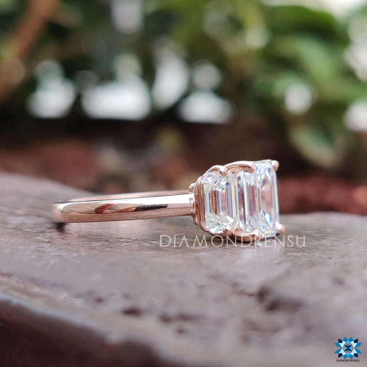 Rose gold three stone engagement ring with prong setting.

