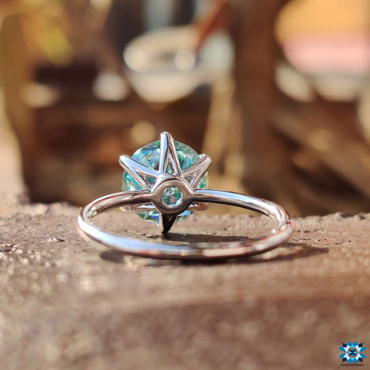 Cyan blue round cut engagement ring with a secure 6 prong setting.
