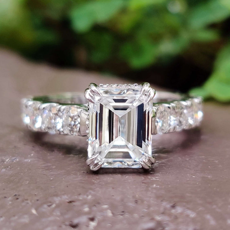Emerald cut hidden halo ring in white gold.

