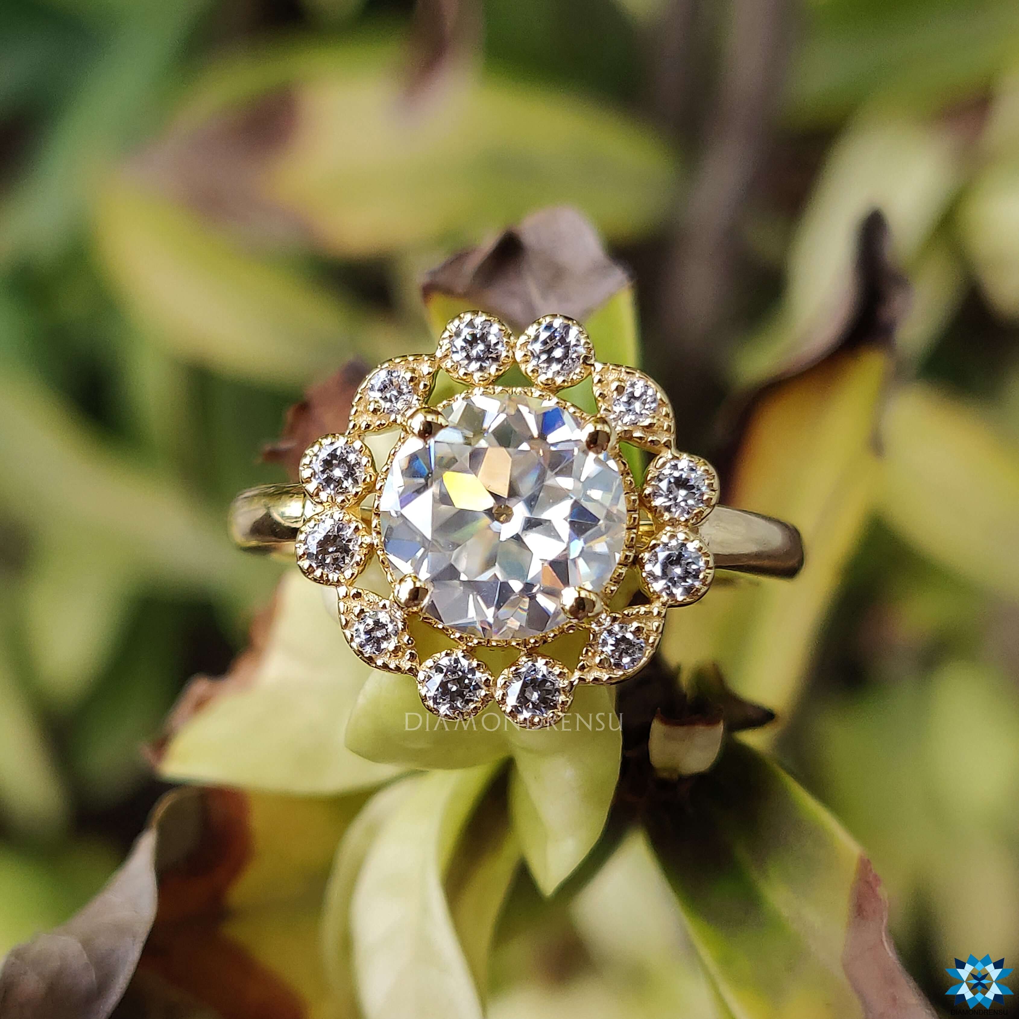 Moissanite halo ring with a round brilliant cut and milgrain detailing.