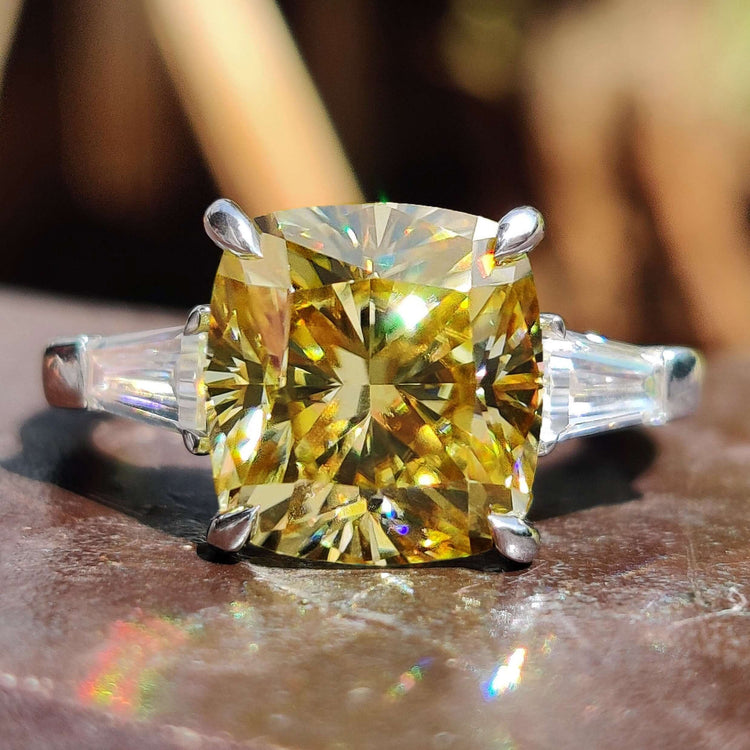 Cushion cut moissanite ring with tapered baguette side stones.
