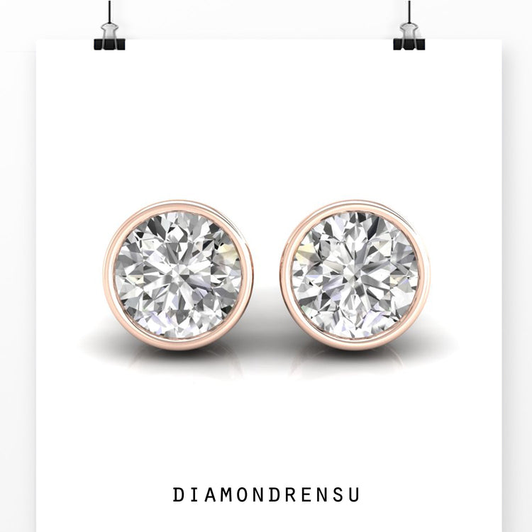 Gold diamond earrings with round cut stones and bezel setting.
