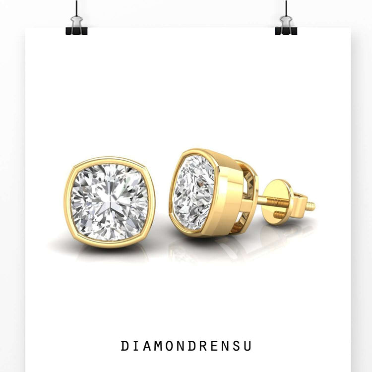 Rose gold bezel earrings holding cushion diamonds.
