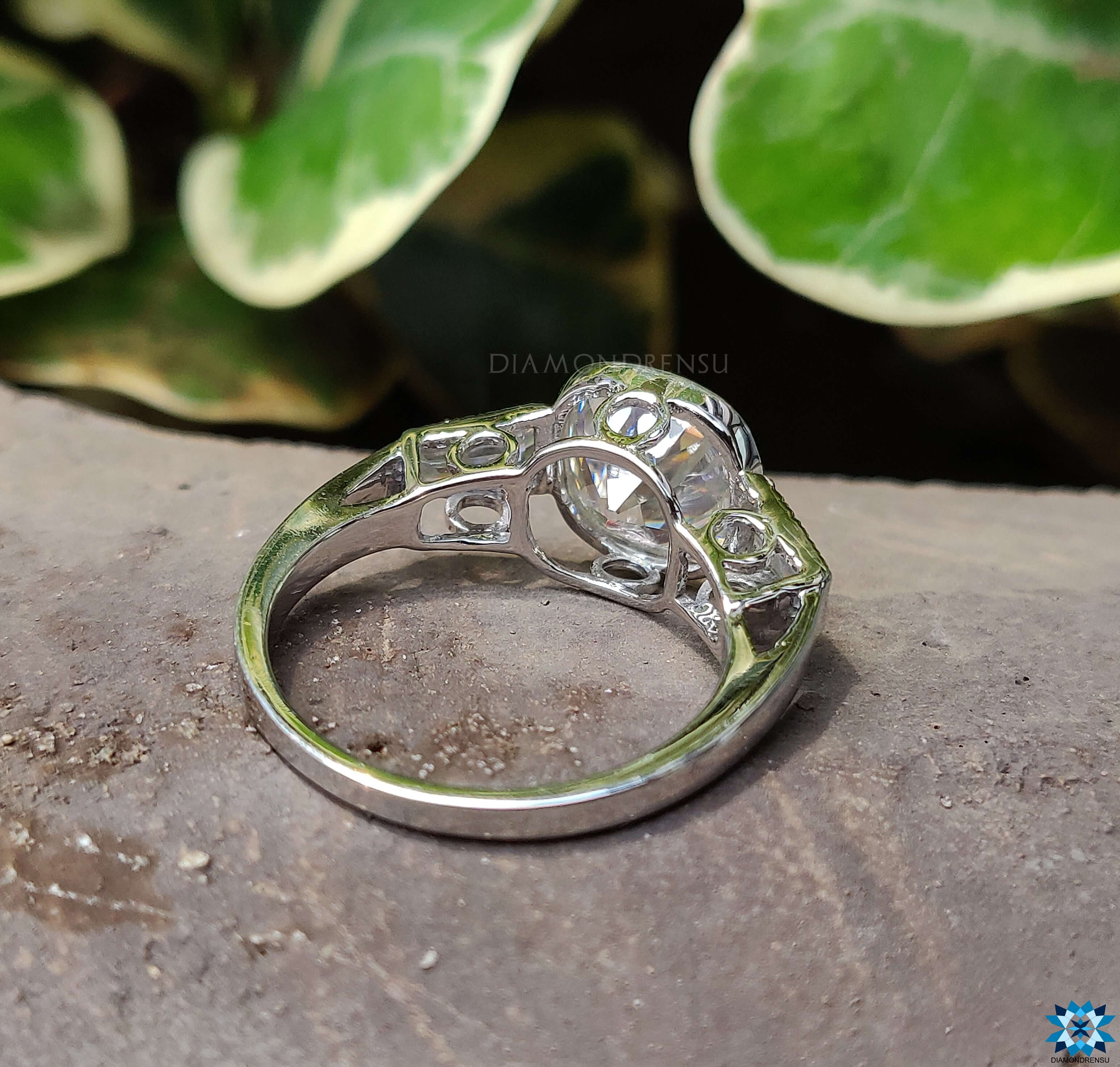 Milgrain ring design adding vintage charm to a modern 3 stone moissanite ring.