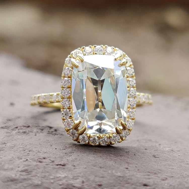 Cushion cut moissanite halo engagement ring in yellow gold.
