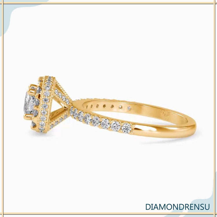Yellow gold ring with cushion diamond and halo setting.

