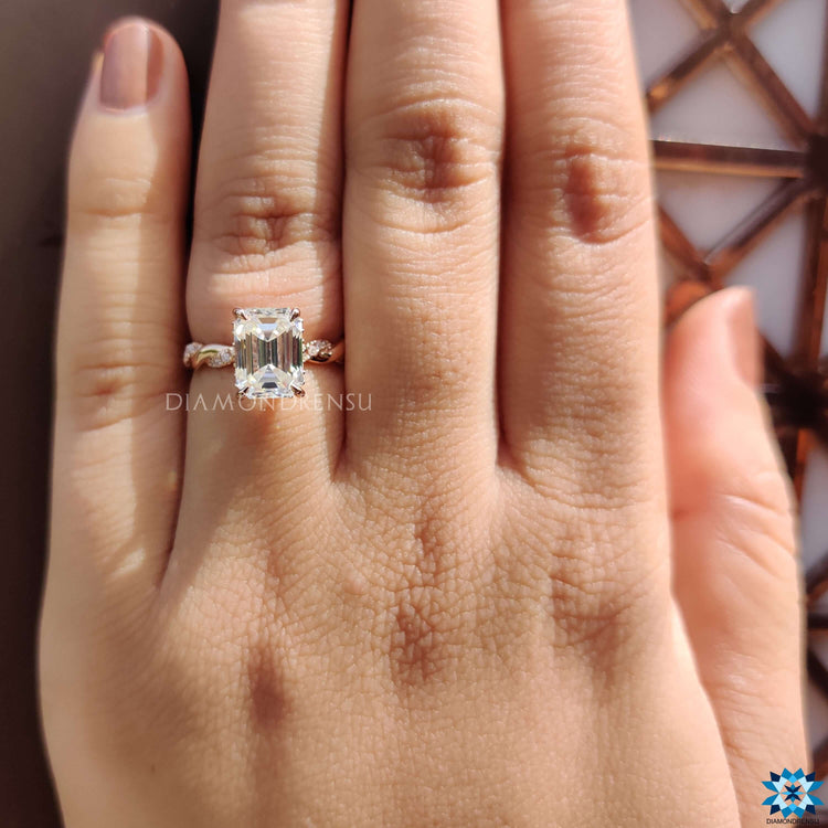 Custom engagement ring with round accents and emerald center.
