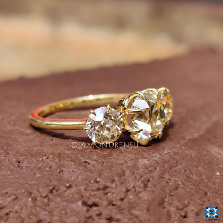 Cushion old mine cut moissanite ring with round side stones.
