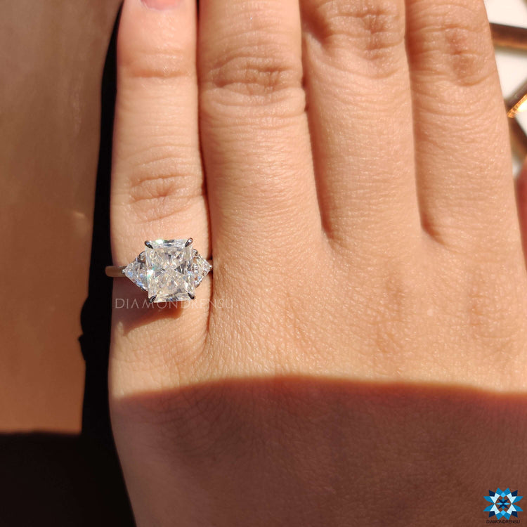 Moissanite engagement ring with three stone layout in white gold.
