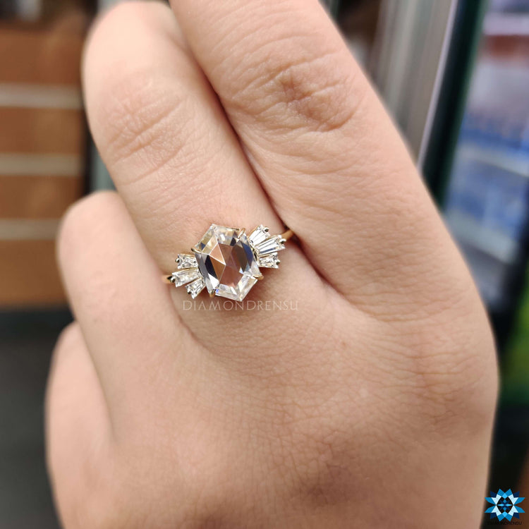 Yellow gold ring with hexagon moissanite and tapered baguette sides.
