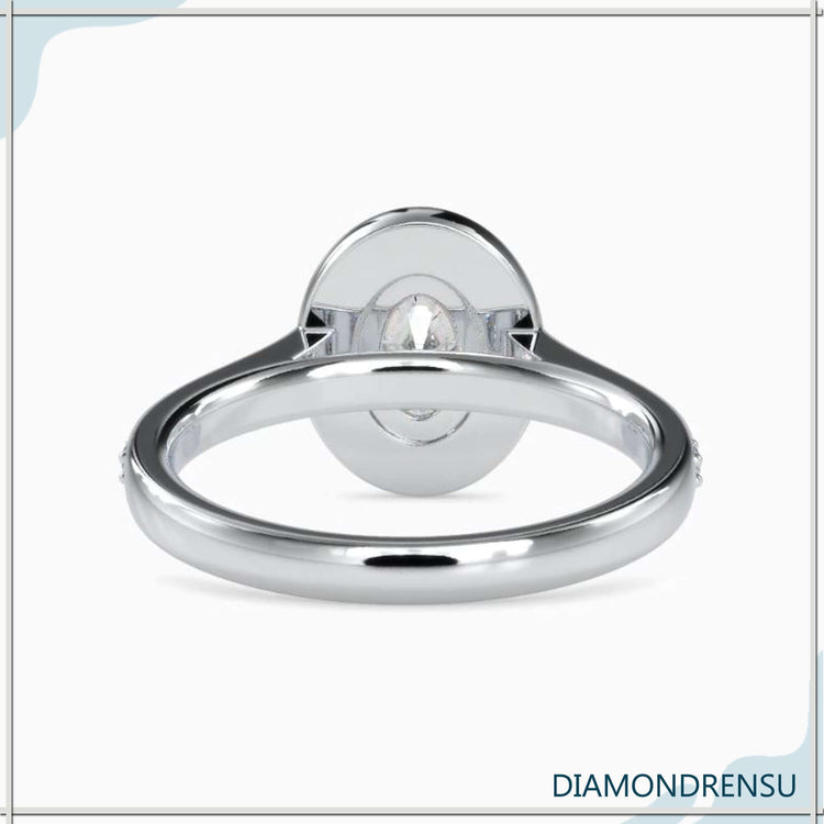 Rose gold diamond ring with round cut halo and oval centre.
