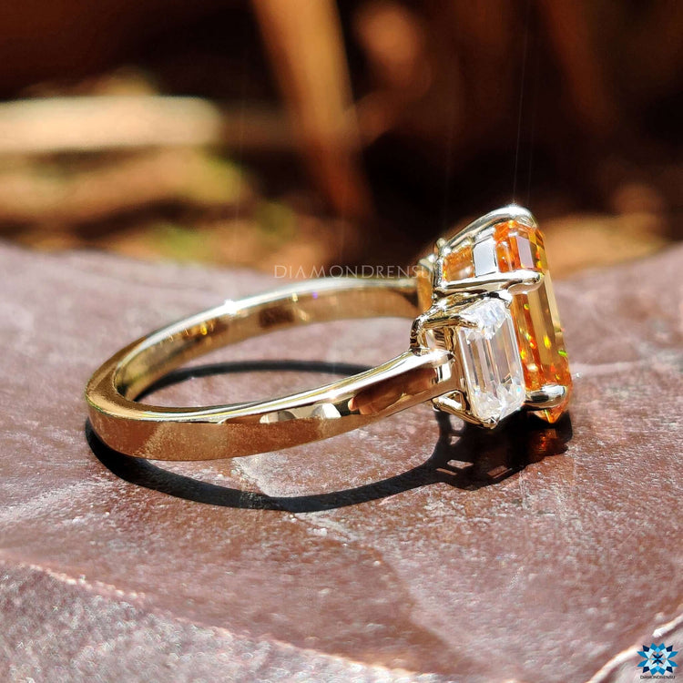 Three stone ring with champagne emerald moissanite center.
