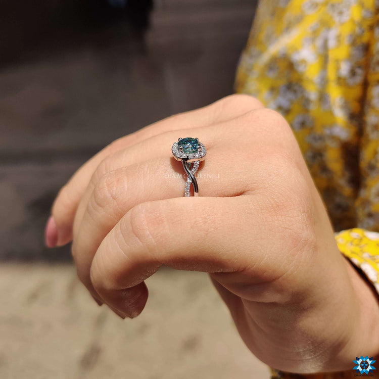 Twisted band ring with blue moissanite.
