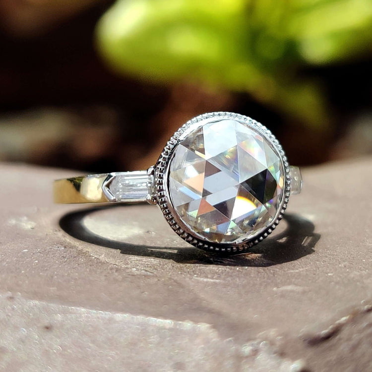 Milgrain bezel engagement ring with three moissanite stones.
