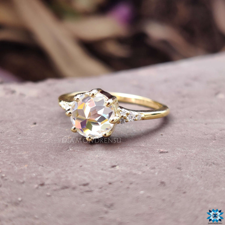 Prong setting ring with round rose cut moissanite and side accents.
